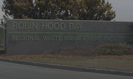 Concrete front gate with green text sign reads Robin Hood Bay Regional Waste Management Facility